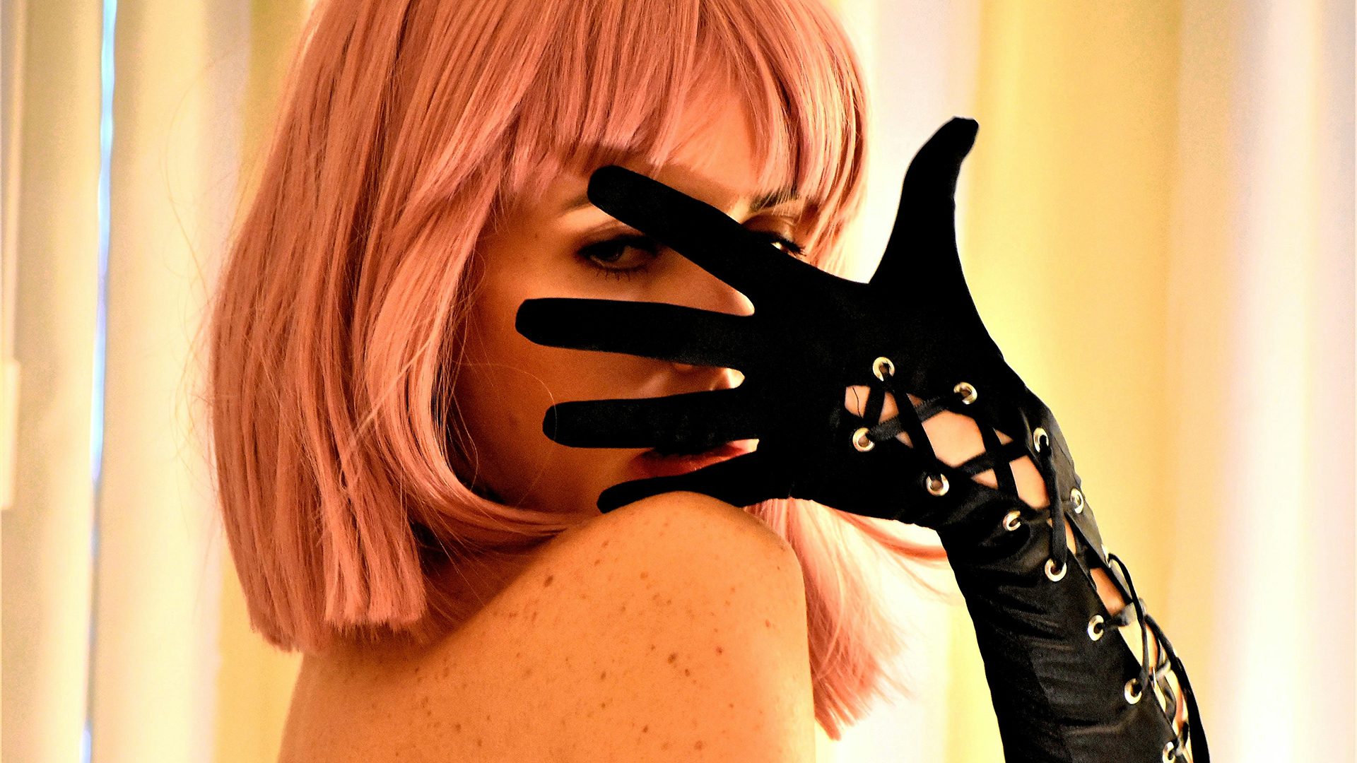 Professional cosplayer in a high-tech studio setting using a 3D printed prop for an OnlyFans content shoot